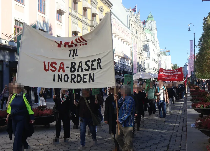 Demonstranter går gjennom Oslo med et banner med teksten «Nei til USA-baser i Norden».